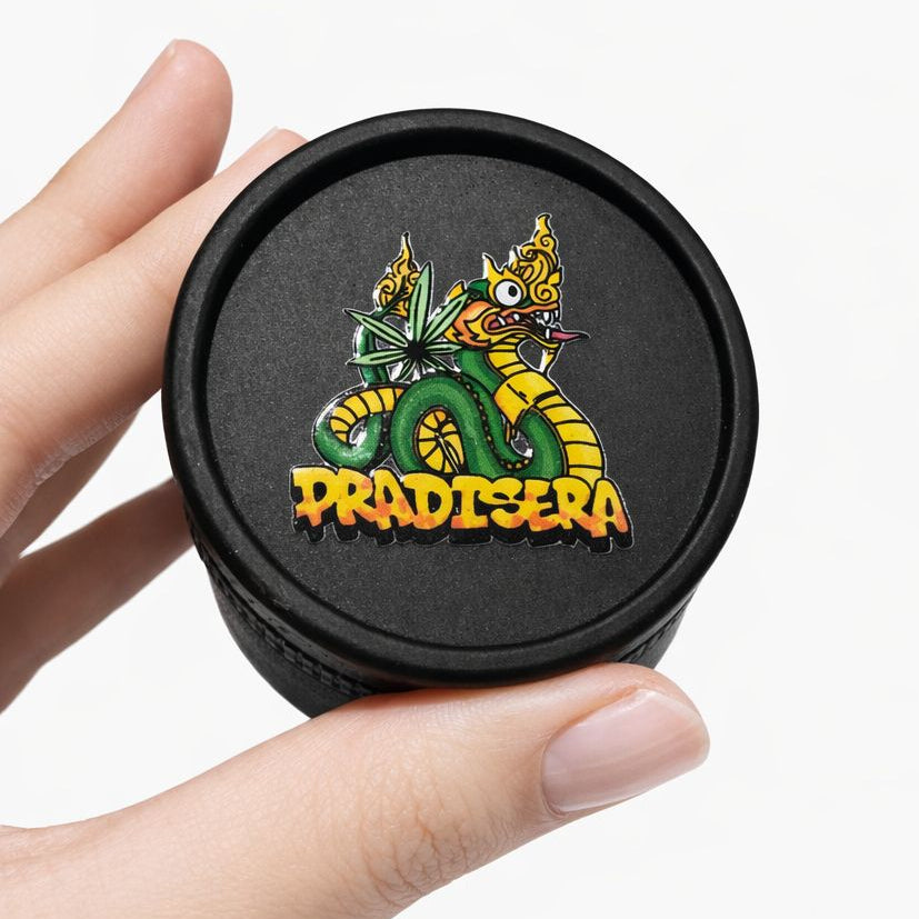 Black container lid with colorful dragon design and 'Pradisera' text held by a hand on a white background